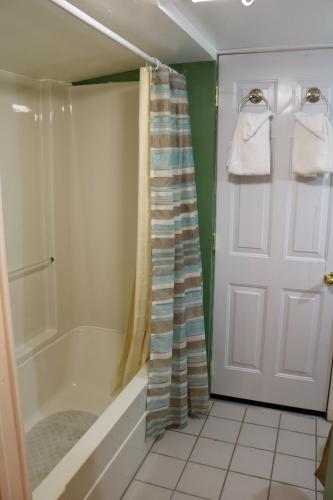 a bathroom with a shower and a tub and a door at Red Caboose Motel & Restaurant in Ronks