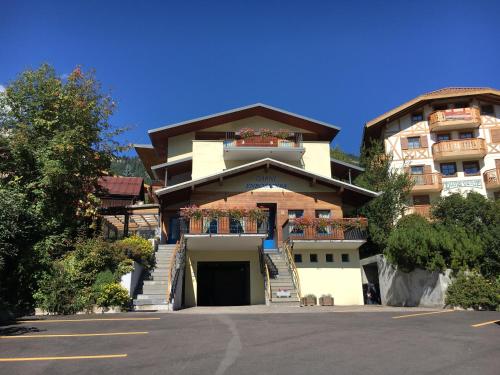 a large building with stairs leading up to it at Garni Enrosadira in Vigo di Fassa