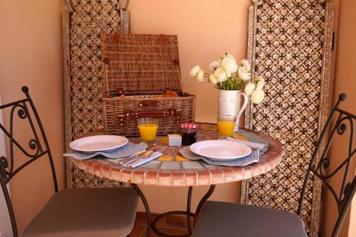 a table with two plates and a vase of flowers at Lone Star House in Sainte-Maxime