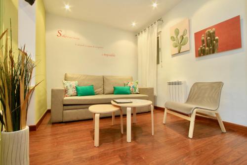 a living room with a couch and a chair at Apartamentos Inside Paseo de los Tristes in Granada