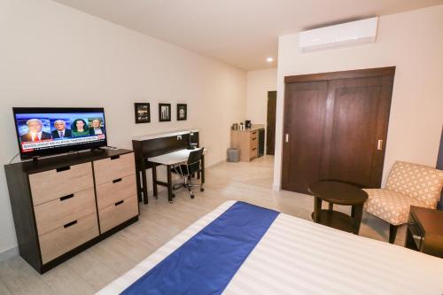 a bedroom with a bed and a flat screen tv at Medano Hotel and Spa in Cabo San Lucas