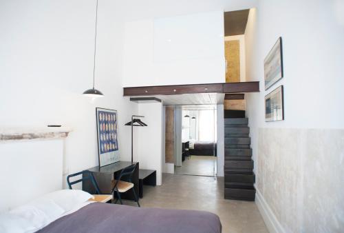 a bedroom with a bed and a desk and a staircase at Belledonne Suite & Gallery in Naples