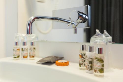 a bathroom counter with a mirror and a sink at Faro Boutique Hotel in Faro