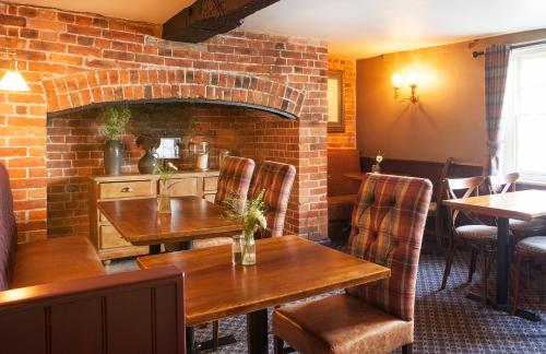 a restaurant with tables and chairs and a brick wall at The Green Dragon in Market Lavington
