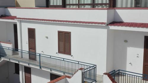 a group of white buildings with stairs and windows at Residence Arcobaleno in San Vito lo Capo