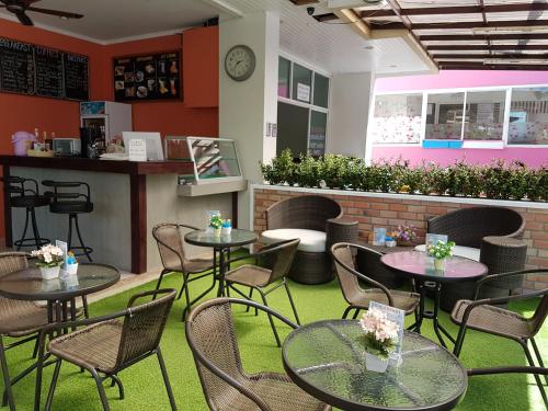 a restaurant with tables and chairs and a counter at Calypso Patong Hotel in Patong Beach