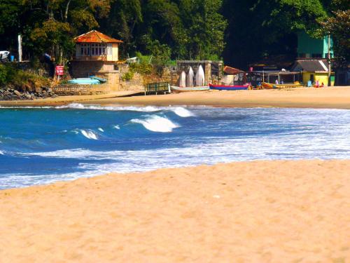 a beach with a water fountain in the background at Pousada Paraguaya in Angra dos Reis