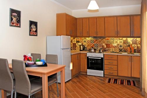 a kitchen with a table and a white refrigerator at Kavadias Apartments in Vasiliki
