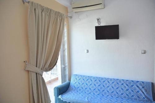 a room with a blue couch and a window at Hotel Germany in Paralia Katerinis