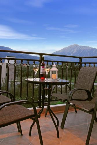 a table with two glasses of wine on a balcony at Kavadias Apartments in Vasiliki