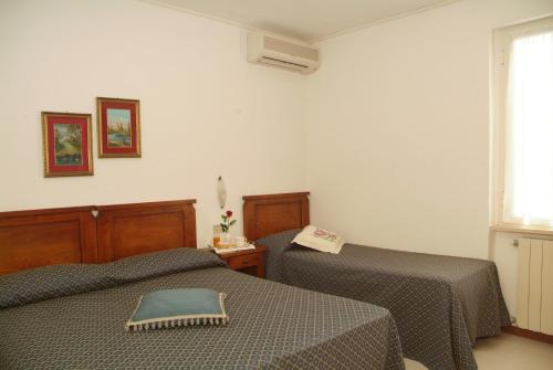 a room with two beds and a window at C.A.V. Residenza Prisco in Marina di Grosseto
