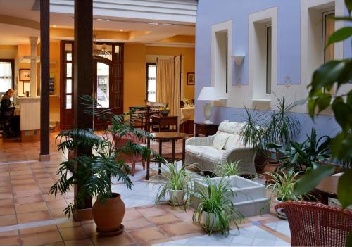 a living room filled with lots of potted plants at Hotel Veracruz in Utrera