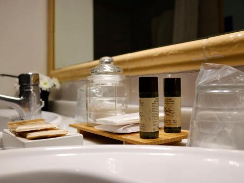 a bathroom sink with two bottles of soap and a mirror at Hotel Veracruz in Utrera