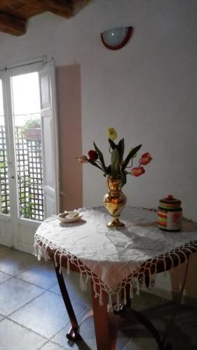 a table with a vase with flowers on it at Piccola Azzurra in Comiso