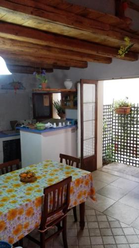 a kitchen with a table and a kitchen with a table and chairs at Piccola Azzurra in Comiso