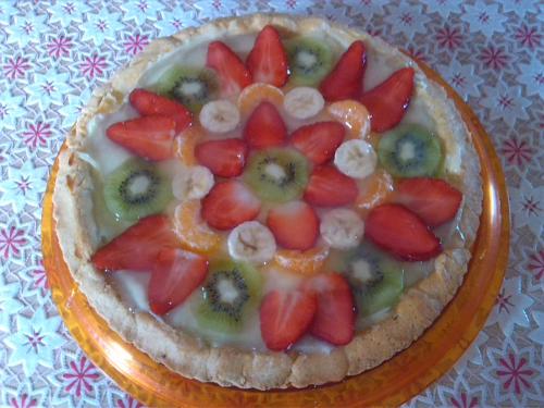 a fruit tart on a plate with strawberries and bananas at B&B Verdeblu in Valderice