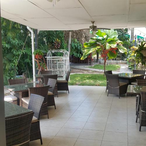 an outdoor patio with tables and chairs and a white umbrella at The Balboa Inn in Panama City