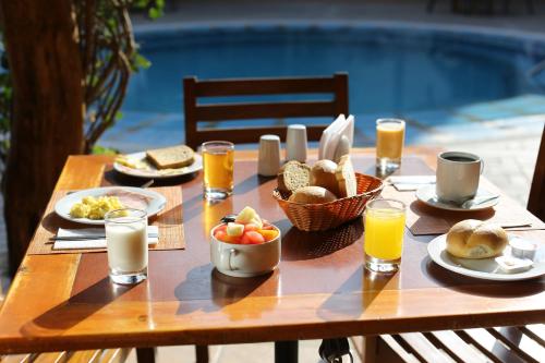 a wooden table with breakfast foods and glasses of orange juice at Casa Andina Standard Nasca in Nazca