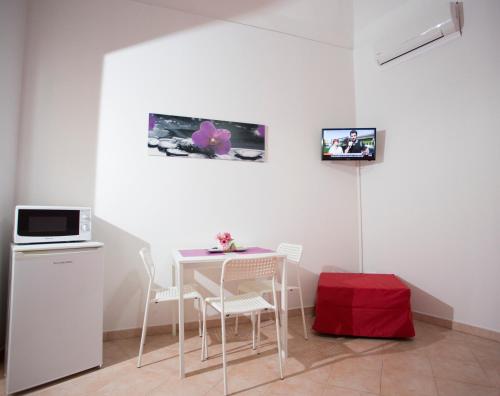 a dining room with a table and chairs and a microwave at Casa del Clown in Trapani