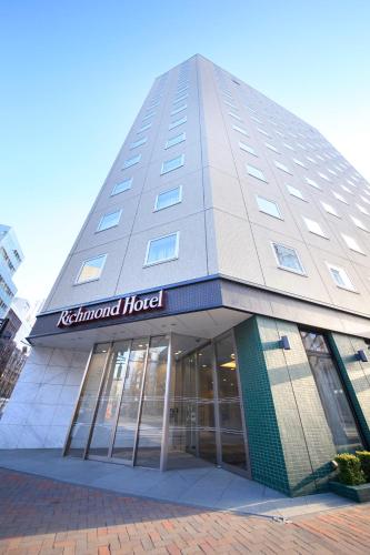a tall building with a sign on the front of it at Richmond Hotel Sapporo Ekimae in Sapporo