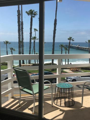 a balcony with a view of the beach and palm trees at Sea Horse Resort in San Clemente
