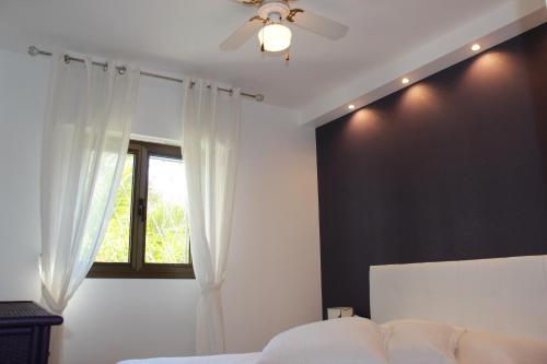 - une chambre avec un ventilateur de plafond et une fenêtre dans l'établissement Central avec Jardin, à Cannes