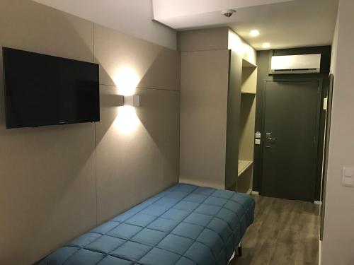 a small room with a bed and a flat screen tv at Hotel do Parque in Viana do Castelo