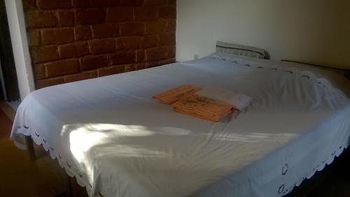 ein weißes Bett mit zwei Kissen darüber in der Unterkunft Pousada Sempre Viva in Milho Verde