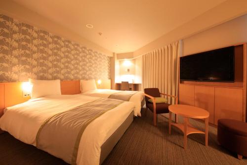 札幌市にあるリッチモンドホテル 札幌駅前の大型ベッド1台、薄型テレビが備わるホテルルームです。
