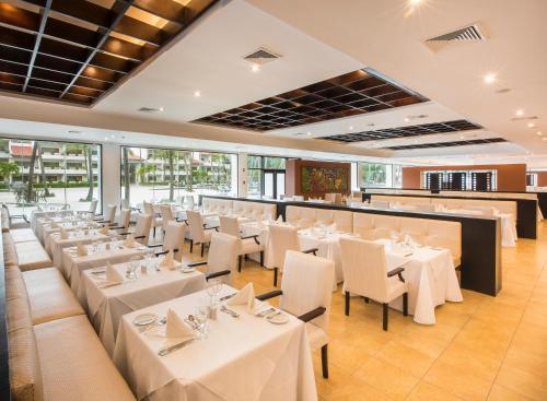 a dining room with white tables and chairs at Occidental Punta Cana - All Inclusive in Punta Cana