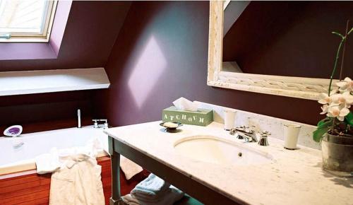 a bathroom with a sink and a mirror and a tub at Nature et Lin in Néville