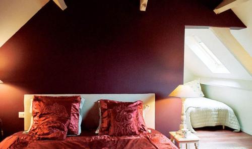 a bedroom with a bed with red pillows at Nature et Lin in Néville