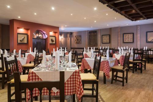 a restaurant with tables and chairs with red and white tablecloths at Occidental Punta Cana - All Inclusive in Punta Cana