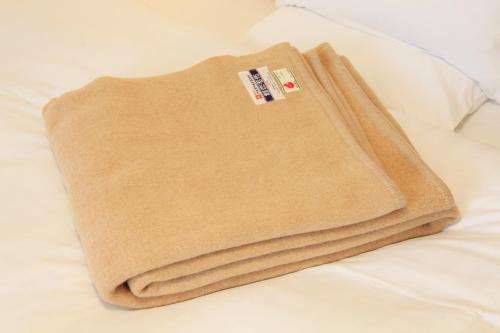 a blanket sitting on top of a bed at Richmond Hotel Sapporo Ekimae in Sapporo