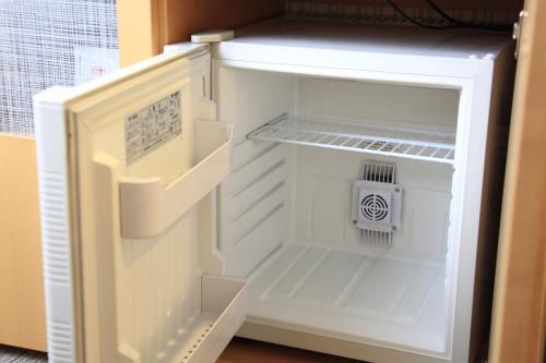 a small white refrigerator with its door open at Richmond Hotel Sapporo Ekimae in Sapporo