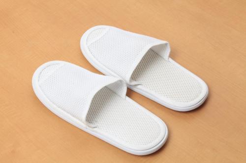 a pair of white flip flops sitting on a table at Richmond Hotel Sapporo Ekimae in Sapporo