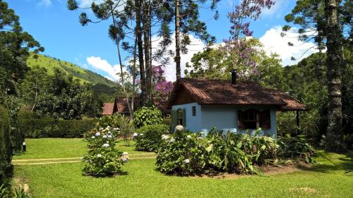 ein kleines Haus inmitten eines Gartens in der Unterkunft Pousada Sítio das Astrapéias in Visconde De Maua