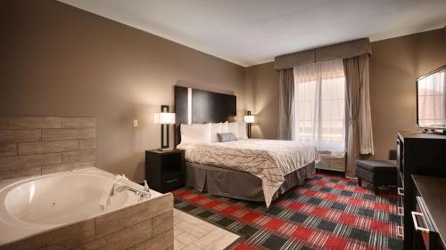 Best Western Casino Inn في فينتون: غرفة في الفندق مع سرير وحوض استحمام