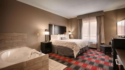 a hotel room with a bed and a bath tub at Best Western Casino Inn in Vinton