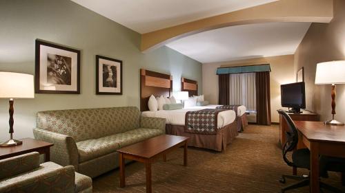 a hotel room with a bedroom with a bed and a couch at Best Western Plus Texarkana Inn and Suites in Texarkana