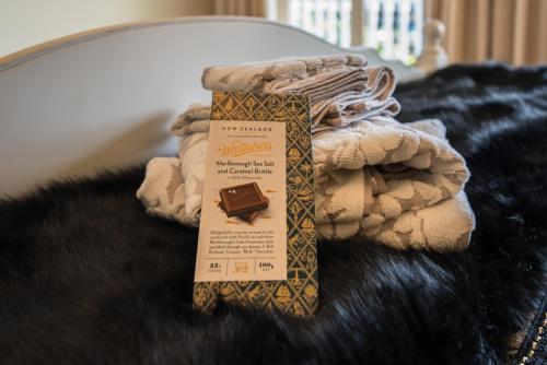 a box of chocolate sitting on top of a blanket at Bellevue Boutique Lodge in Taupo