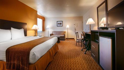 Best Western Sawmill Inn في Heber: غرفة في الفندق مع سرير ومكتب