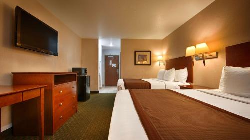 a hotel room with two beds and a flat screen tv at Best Western Parker Inn in Parker