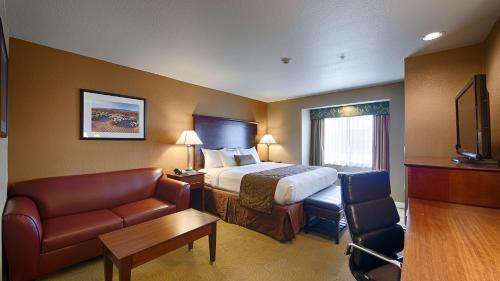 Habitación de hotel con cama y silla en Best Western California City Inn & Suites, en California City