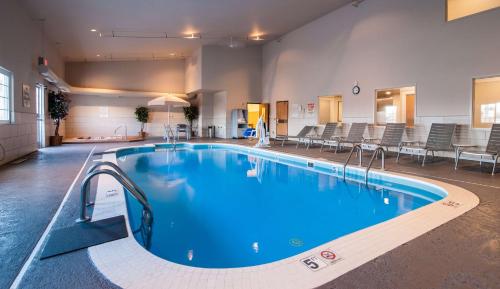 a large swimming pool in a building with chairs at Best Western Plus University Park Inn & Suites in Ames