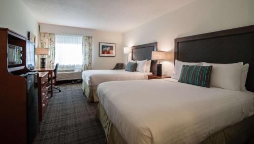 a hotel room with two beds and a window at Best Western Plus University Park Inn & Suites in Ames