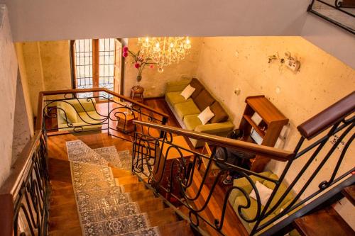 a room with a staircase with a couch and chairs at Hotel Tikary in Arequipa