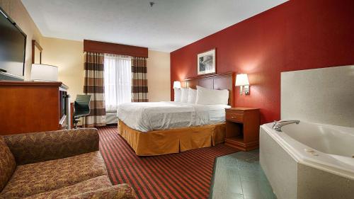 ein Hotelzimmer mit einem Bett und einer Badewanne in der Unterkunft Best Western Canton Inn in Canton