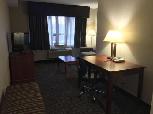 a hotel room with a desk and a television at Best Western Gateway Adirondack Inn in Utica