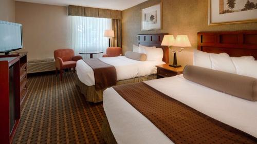 Baymont Inn & Suites في ماريتا: غرفة فندقية بسريرين وتلفزيون بشاشة مسطحة